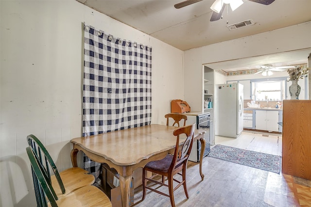 dining space with ceiling fan, sink, and light hardwood / wood-style floors