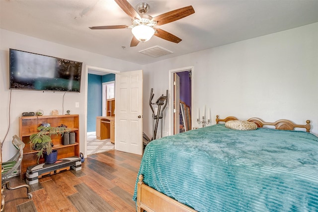 bedroom with ensuite bathroom, ceiling fan, and hardwood / wood-style floors