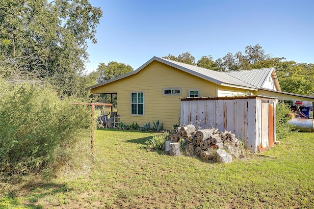 view of side of home with a yard