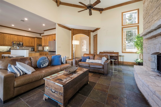 living room with crown molding, a towering ceiling, and ceiling fan