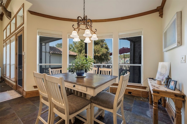 dining space featuring crown molding and an inviting chandelier