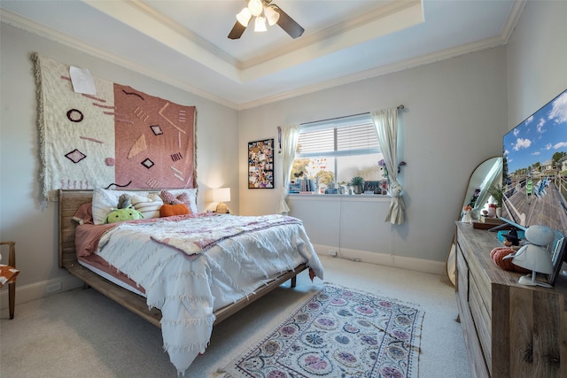 carpeted bedroom featuring ceiling fan, a raised ceiling, and ornamental molding