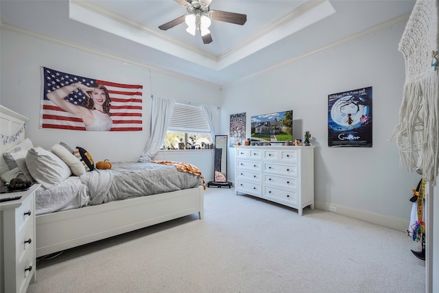 bedroom with ceiling fan, a raised ceiling, and light colored carpet