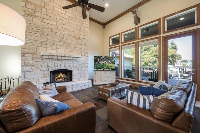 living room featuring ornamental molding, a high ceiling, a fireplace, and ceiling fan