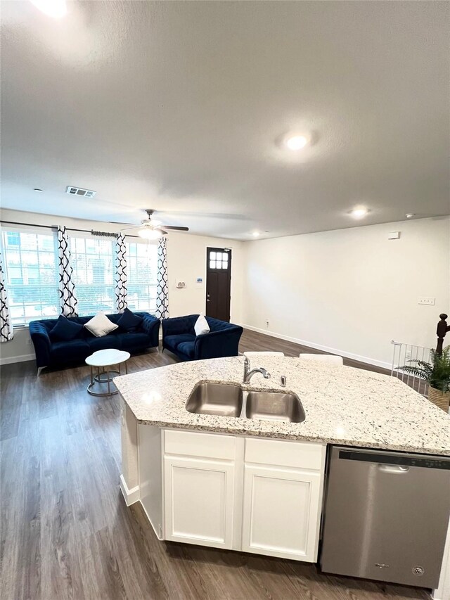 kitchen featuring sink, a center island with sink, appliances with stainless steel finishes, light stone countertops, and white cabinets