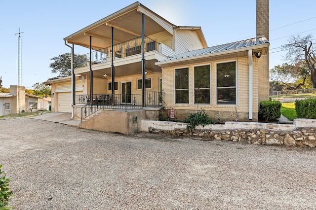 view of front of property with a garage, a balcony, and covered porch