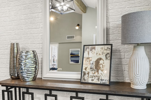 details featuring an inviting chandelier and beam ceiling