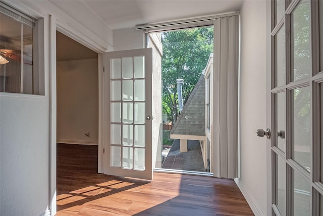 doorway to outside with baseboards and wood finished floors