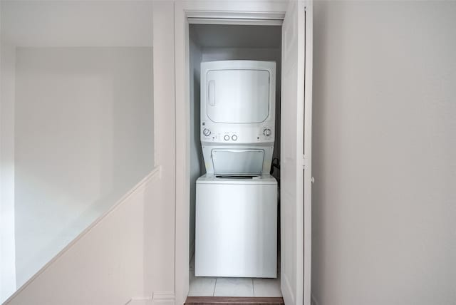 laundry area featuring light tile patterned floors and stacked washer and dryer