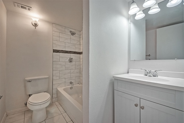 full bathroom featuring tiled shower / bath, vanity, tile patterned flooring, and toilet