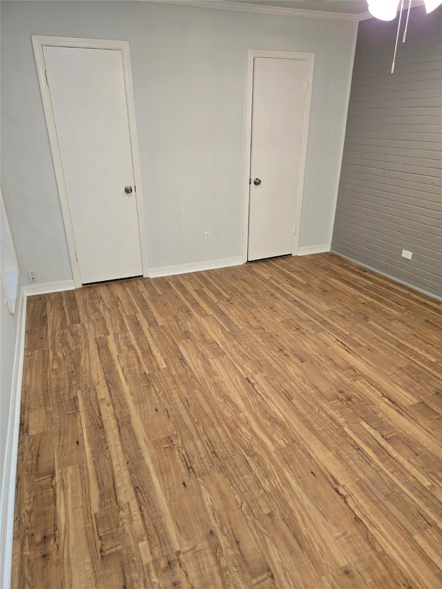 107 Malibu Dr, Shreveport, LA 71115 - empty room with baseboards, ornamental molding, wood finished floors, and brick wall