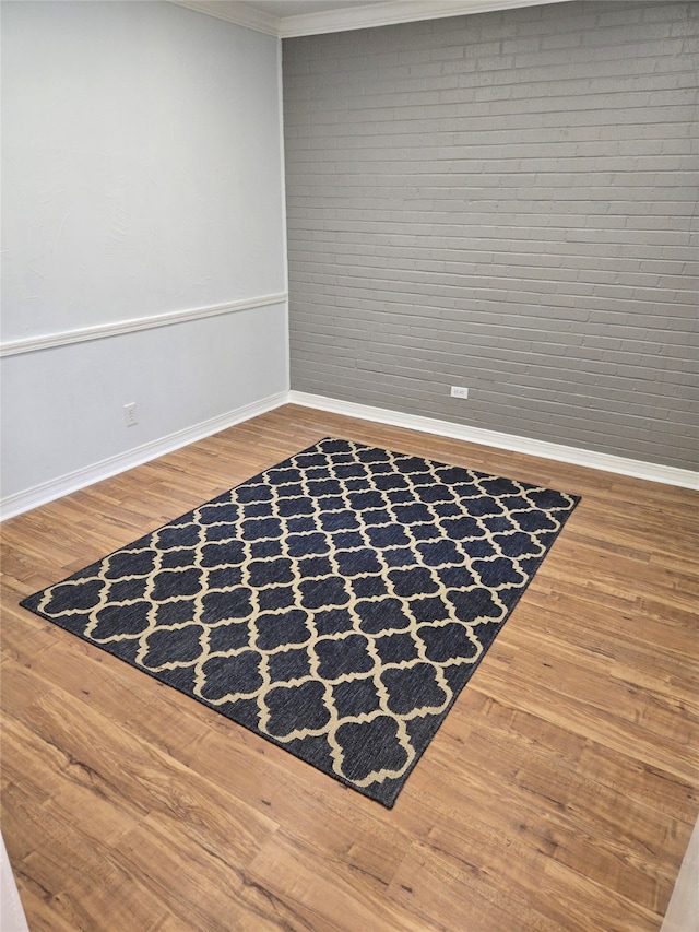 empty room with ornamental molding and hardwood / wood-style floors