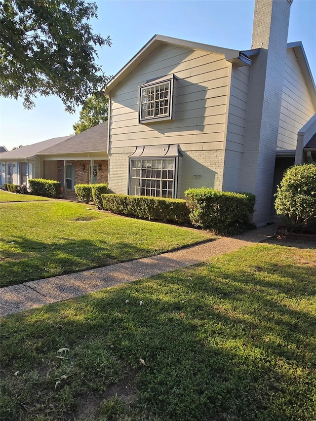 107 Malibu Dr, Shreveport, LA 71115 - view of home's exterior featuring brick siding, a lawn, and a chimney