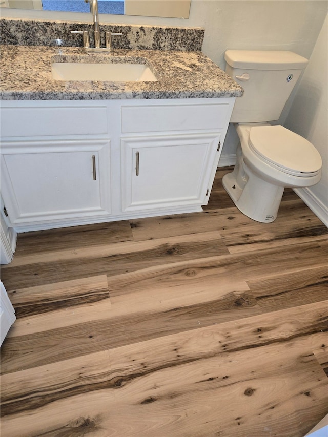 bathroom featuring hardwood / wood-style floors, vanity, and toilet