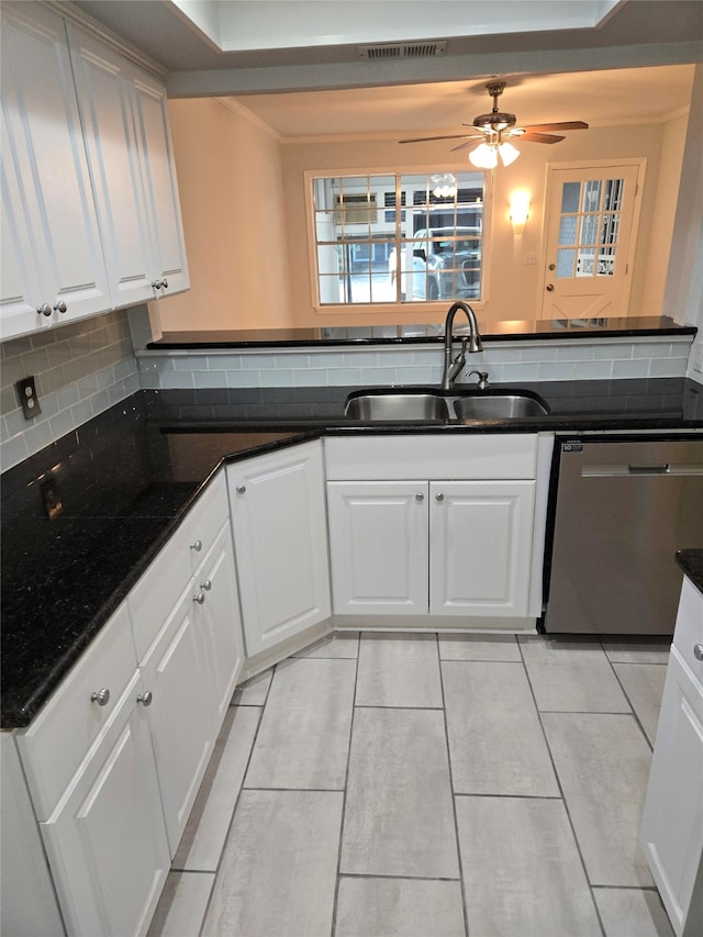 kitchen with decorative backsplash, white cabinets, dark stone countertops, sink, and dishwasher