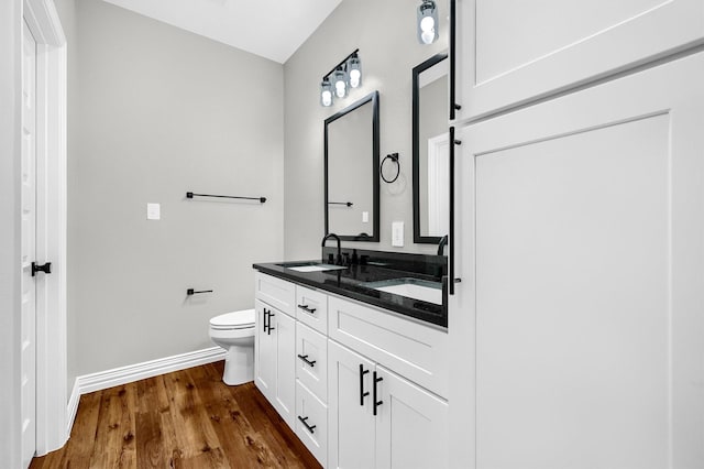 bathroom featuring wood-type flooring, vanity, and toilet