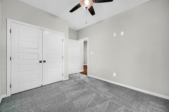 unfurnished bedroom featuring a closet, dark carpet, and ceiling fan