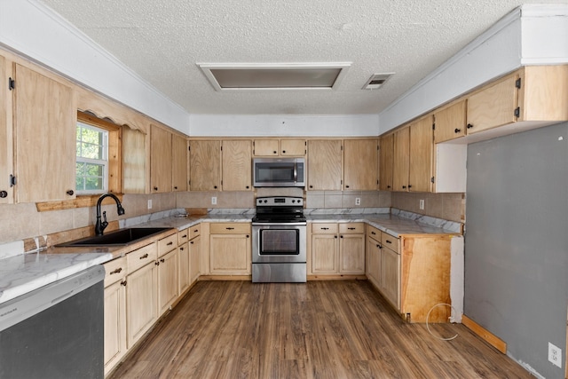 kitchen with sink, a textured ceiling, backsplash, dark wood-type flooring, and appliances with stainless steel finishes