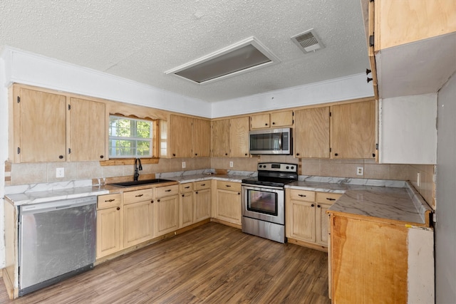 kitchen featuring stainless steel appliances, sink, a textured ceiling, and hardwood / wood-style flooring