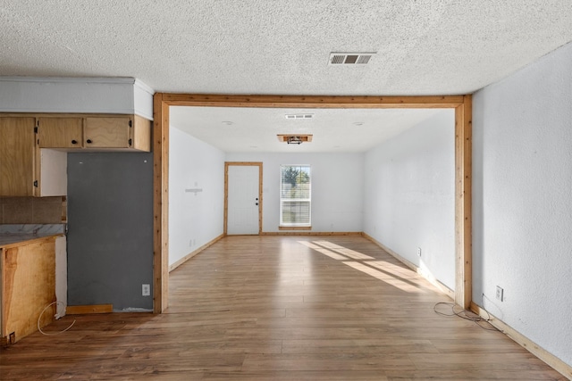 interior space featuring a textured ceiling and light wood-type flooring