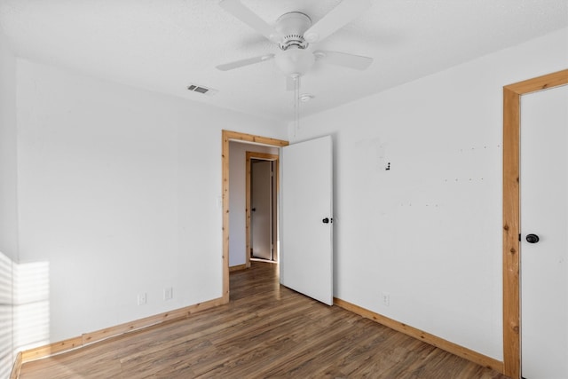 empty room featuring ceiling fan and dark hardwood / wood-style flooring