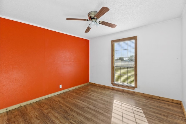 empty room featuring ornamental molding, ceiling fan, hardwood / wood-style floors, and a textured ceiling