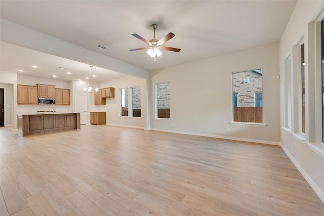 unfurnished living room featuring light hardwood / wood-style floors and ceiling fan with notable chandelier