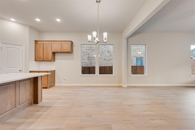 kitchen featuring tasteful backsplash, a chandelier, light hardwood / wood-style flooring, and pendant lighting