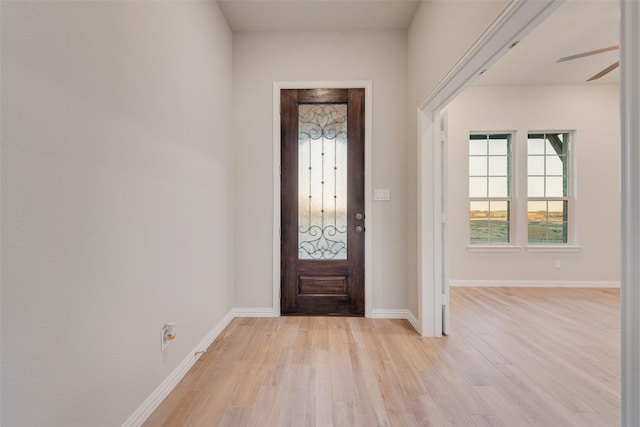 foyer entrance with ceiling fan and light hardwood / wood-style floors