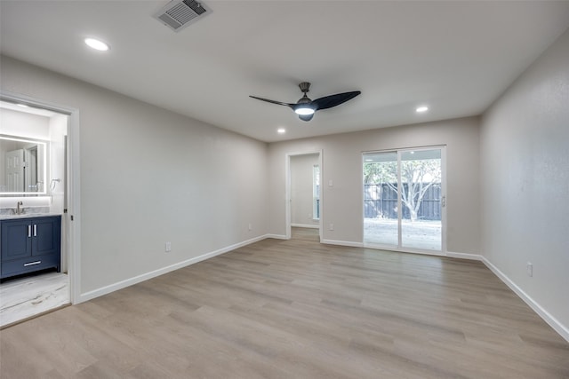 spare room featuring sink, light hardwood / wood-style floors, and ceiling fan