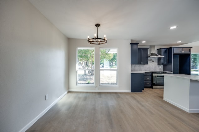 kitchen with hardwood / wood-style floors, tasteful backsplash, black fridge, stainless steel stove, and wall chimney exhaust hood