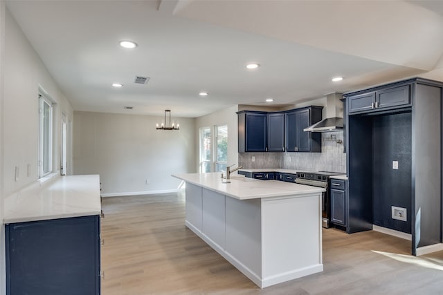 kitchen featuring light stone counters, electric range, wall chimney range hood, and light hardwood / wood-style flooring