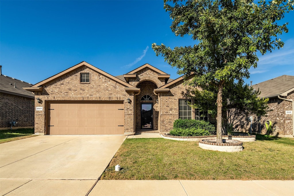 view of front of house featuring a garage and a front lawn