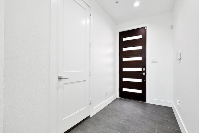 foyer featuring dark tile patterned floors