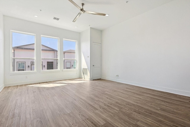 unfurnished room with recessed lighting, a ceiling fan, visible vents, baseboards, and light wood-type flooring