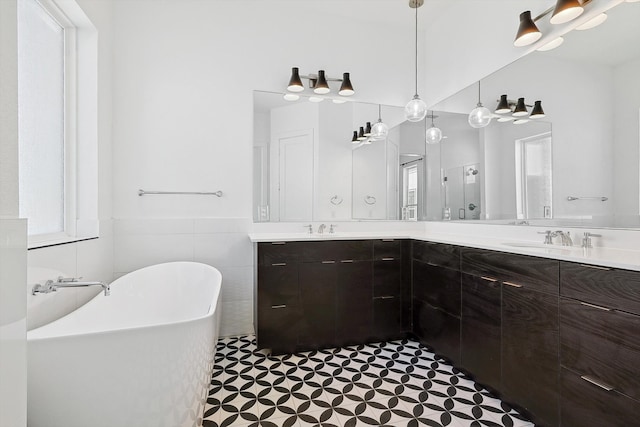 bathroom featuring a bathing tub, vanity, and tile walls