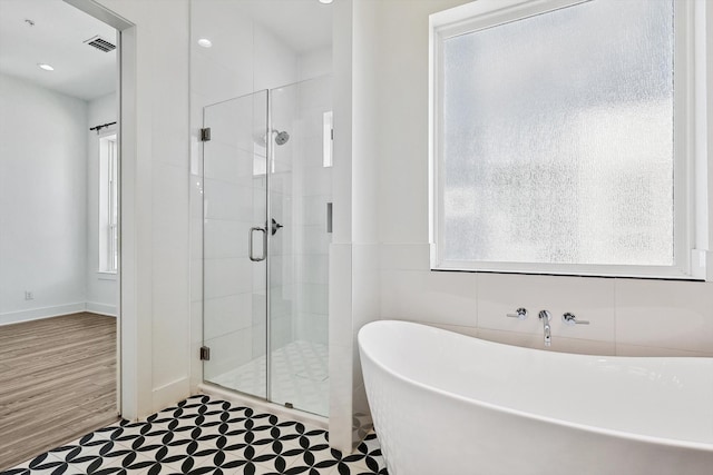 bathroom with hardwood / wood-style flooring and plus walk in shower