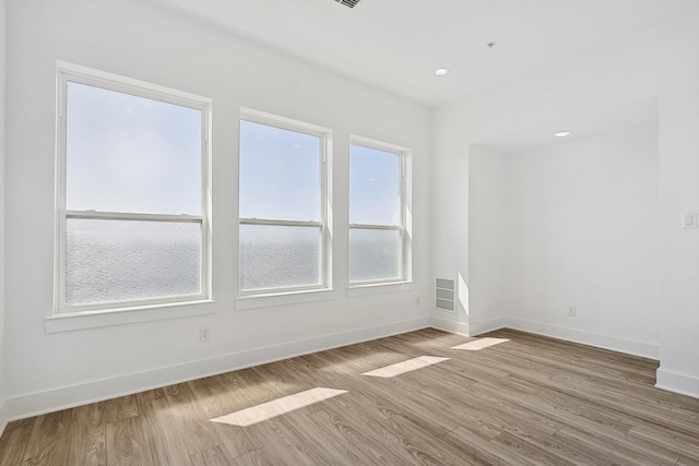 unfurnished room featuring recessed lighting, light wood-type flooring, and baseboards