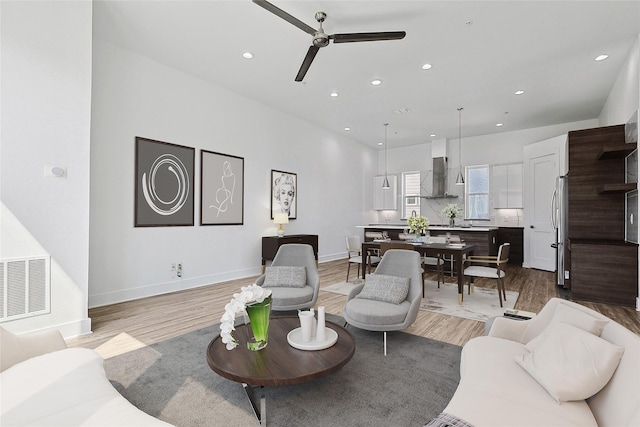 living area featuring light wood-style floors, recessed lighting, and visible vents