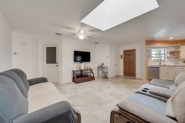 living room featuring ceiling fan and a skylight