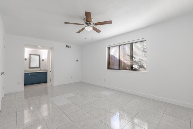 unfurnished bedroom featuring ensuite bathroom, ceiling fan, and light tile patterned flooring