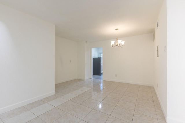 spare room with light tile patterned flooring and a notable chandelier