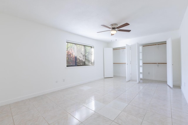 unfurnished bedroom with multiple closets, ceiling fan, and light tile patterned floors