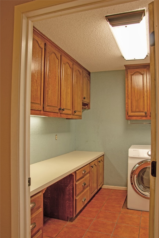 washroom featuring light tile patterned floors, cabinets, and washer / dryer