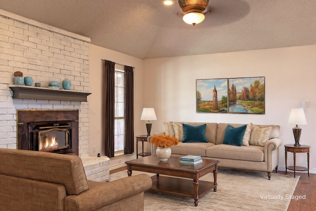 living room featuring hardwood / wood-style flooring, plenty of natural light, a textured ceiling, and vaulted ceiling