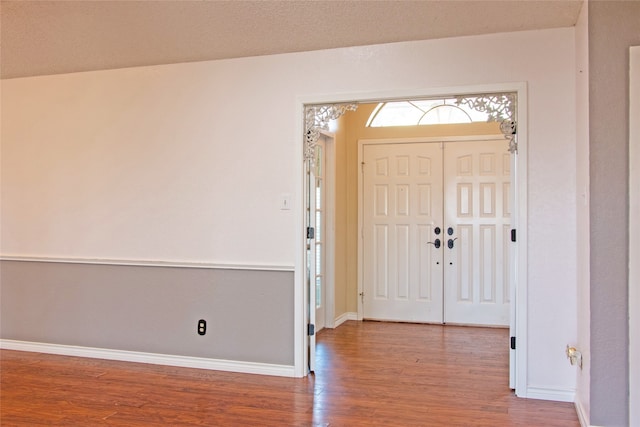 entryway with hardwood / wood-style floors and a textured ceiling