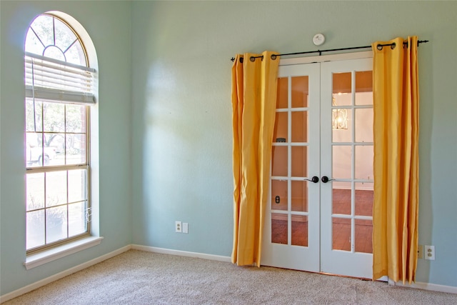 carpeted spare room featuring french doors