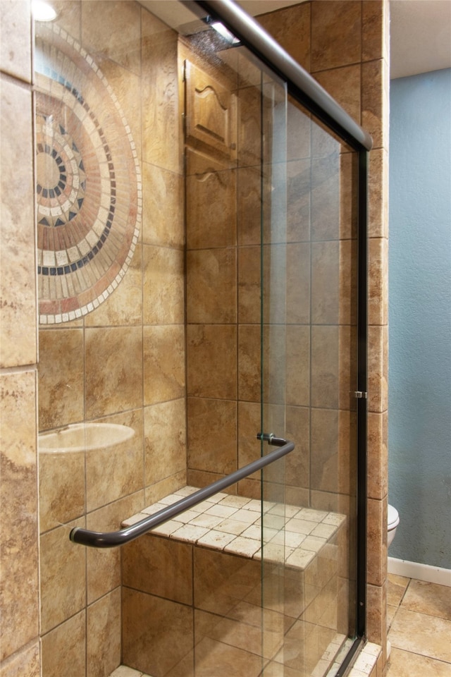 bathroom featuring toilet and a shower with shower door