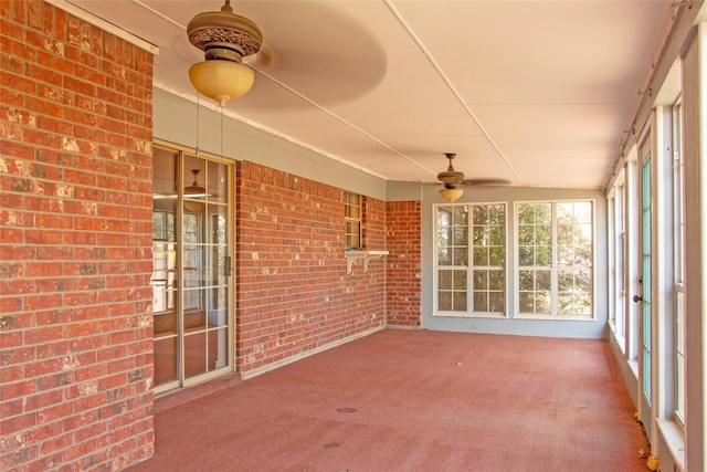 unfurnished sunroom featuring ceiling fan