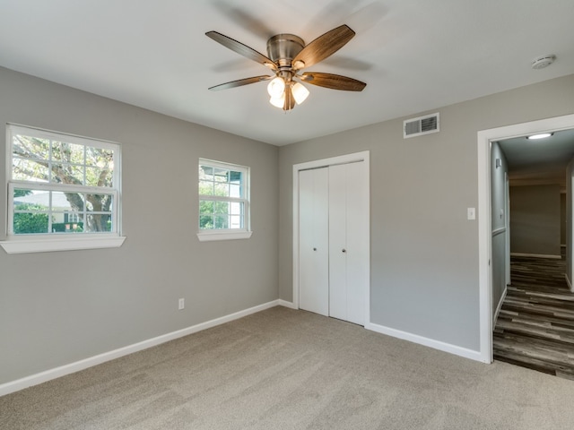 unfurnished bedroom featuring light carpet, ceiling fan, and a closet